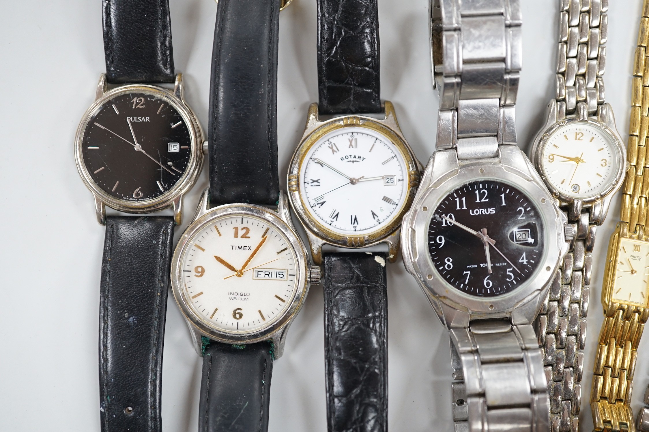 Seven assorted modern wrist watches including Pulsar and Rotary, a 9ct and 'silver' eternity ring, a case amber cigarette holder and two white metal brooches, including one with enamel.